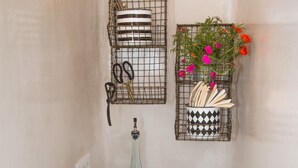 Une petite cuisine équipée d’un grille-pain, d’un petit vase avec des fleurs, d’un service d’assiettes et d’une machine à café.