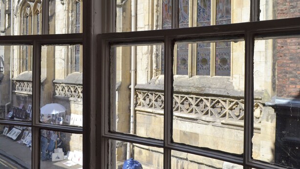A window with a view of a historic building with arched windows and intricate stonework. - 4 bedroom accommodation in York (York)