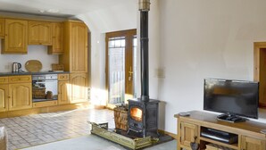 A cozy living room with a fireplace, wooden furniture, and a television.