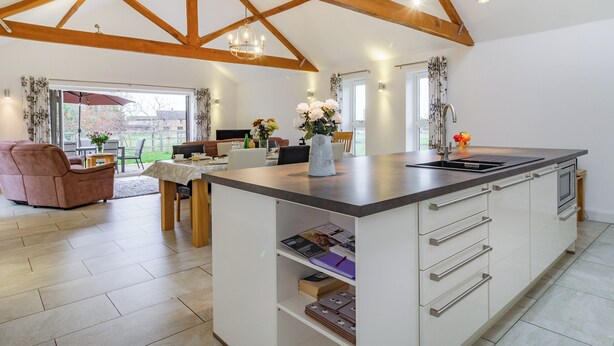 A spacious kitchen with a large island, wooden beams, and pendant lighting. - 3 bedroom accommodation in Wicken, near Ely (Wicken, near Ely)