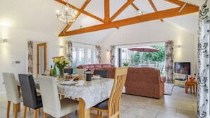 A spacious dining area with a wooden ceiling, a dining table set with chairs, and a sofa in the background. - 3 bedroom accommodation in Wicken, near Ely (Wicken, near Ely)