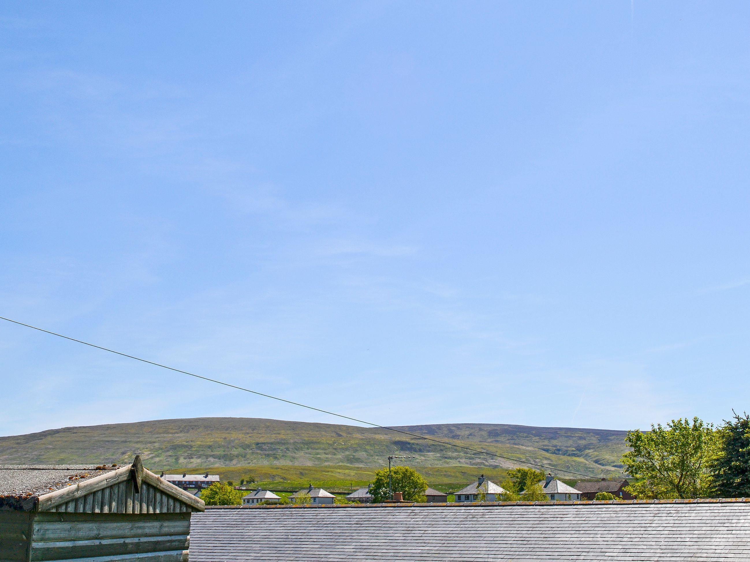 A rural village with traditional houses and a hill in the background.