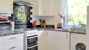 A modern kitchen with white cabinets, a stove, oven, and a dishwasher.