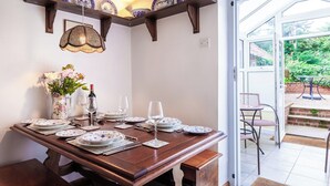 A dining table set with plates, glasses, and a vase of flowers. - 2 bedroom accommodation in Docking, near Hunstanton (Docking, near Hunstanton)
