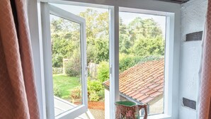 A window with a view of a garden and a tiled roof. - 2 bedroom accommodation in Docking, near Hunstanton (Docking, near Hunstanton)