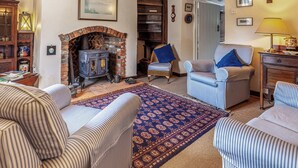 A cozy living room with striped sofas, a patterned rug, a fireplace, and a bookshelf. - 2 bedroom accommodation in Docking, near Hunstanton (Docking, near Hunstanton)