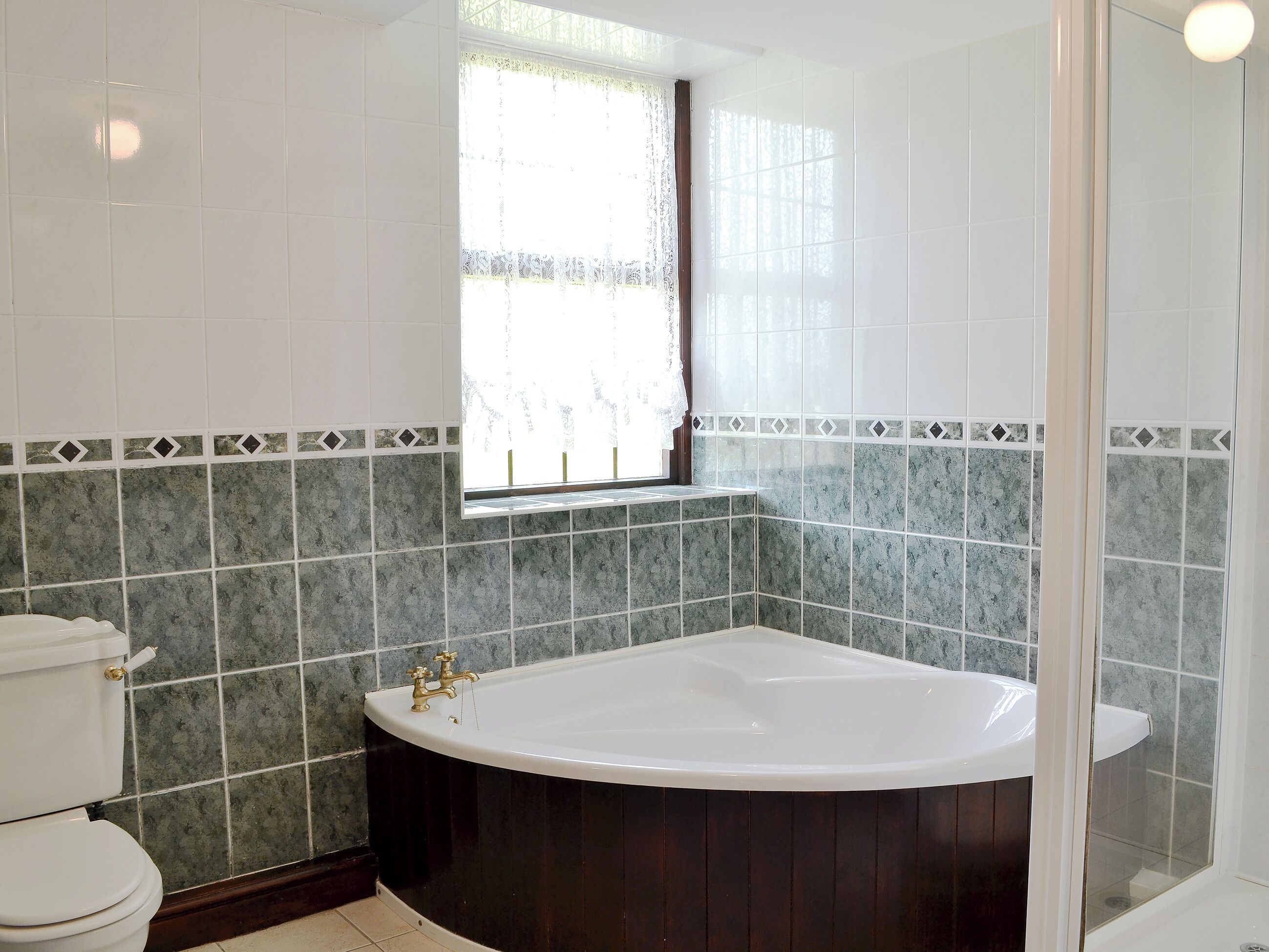 A bathroom with a freestanding bathtub, a toilet, and a window with a view.