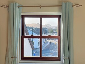 A window with a view of a street and mountains.