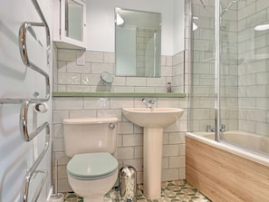 A bathroom with a toilet, sink, and shower.