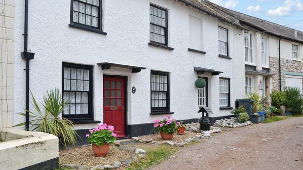A traditional white building with black-framed windows, a red door, and a stone chimney. - 3 bedroom accommodation in Lympstone, near Exmouth (Lympstone, near Exmouth)