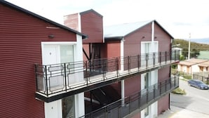 A two-story building with a balcony. - Complejo los Guindos - Ushuaia Flat (Ushuaia)
