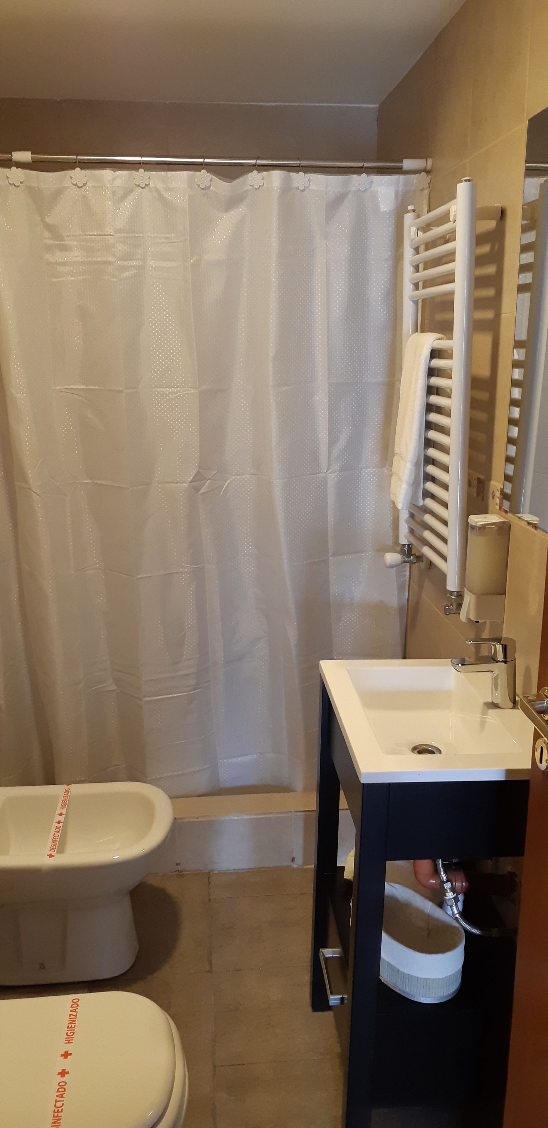 Un baño con inodoro, bidé y lavamanos.