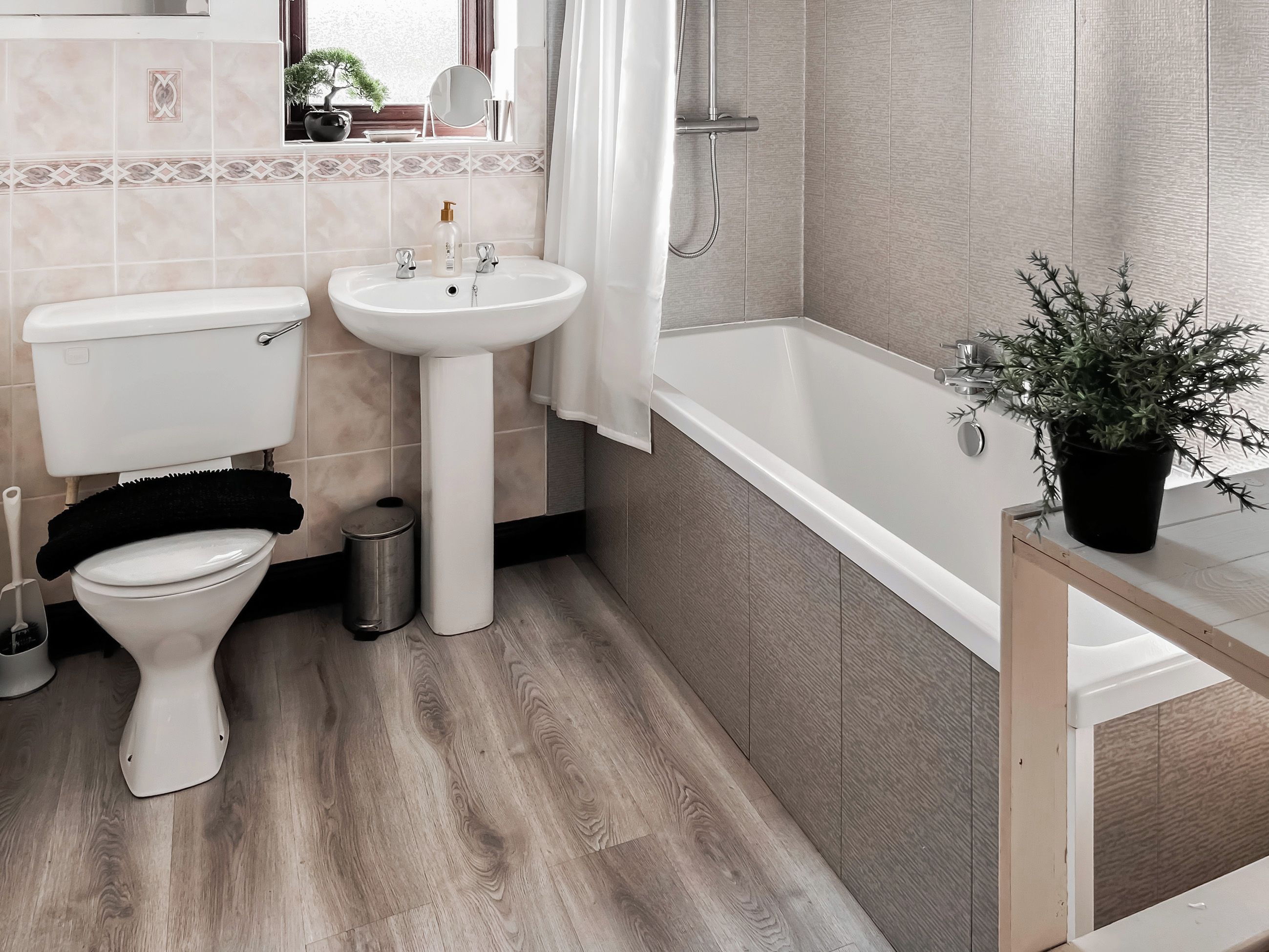 A bathroom with a toilet, sink, and bathtub.