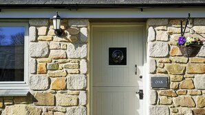 A stone house with a white door, a window, and a sign reading "OAK". - 3 bedroom accommodation in Mawla, near Porthtowan (Mawla, near Porthtowan)