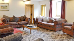 A living room with patterned sofas, a coffee table, and a rug. - Brothersfield Cottage (Hartsop, near Patterdale)