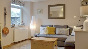 A cozy living room with a sofa, a wooden chest, a lamp, and a radiator. - 1 bedroom accommodation in Ambleside (Ambleside)