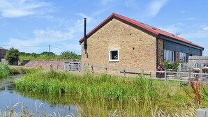 A brick building with a red roof, a small window, and a chimney. - 4 bedroom accommodation in Rye Foreign, Rye (Rye Foreign, Rye)