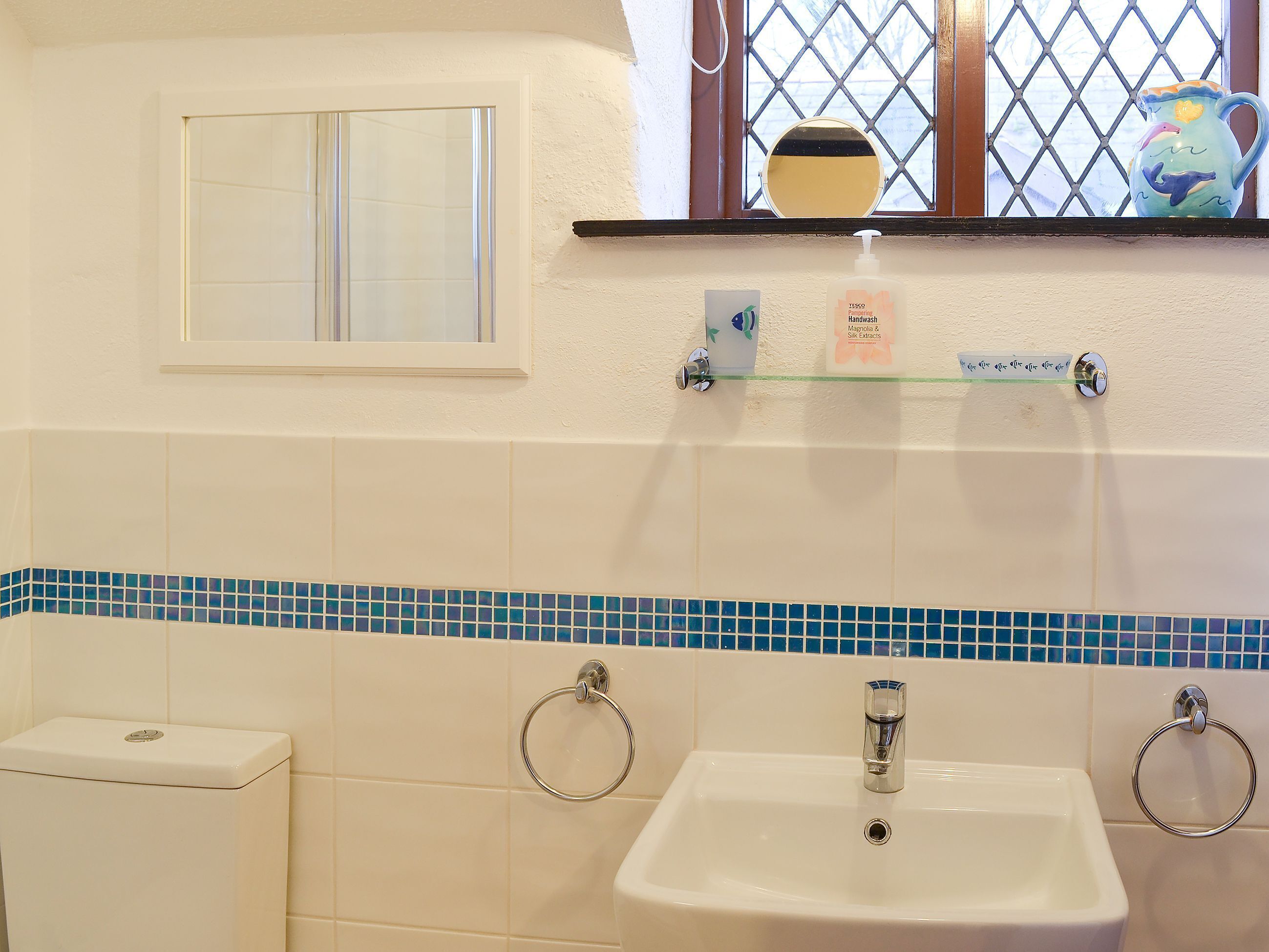 Ein Badezimmer mit Toilette, Waschbecken und Fenster.