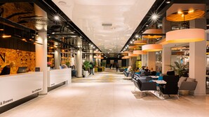A modern hotel lobby with a reception desk, seating area, and a spa & wellness section. - Hamilton Conference Hotel Spa & Wellness (Swinoujscie)
