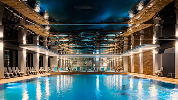 An indoor swimming pool with a modern design, featuring a central diving area and multiple lanes. - Hamilton Conference Hotel Spa & Wellness (Swinoujscie)