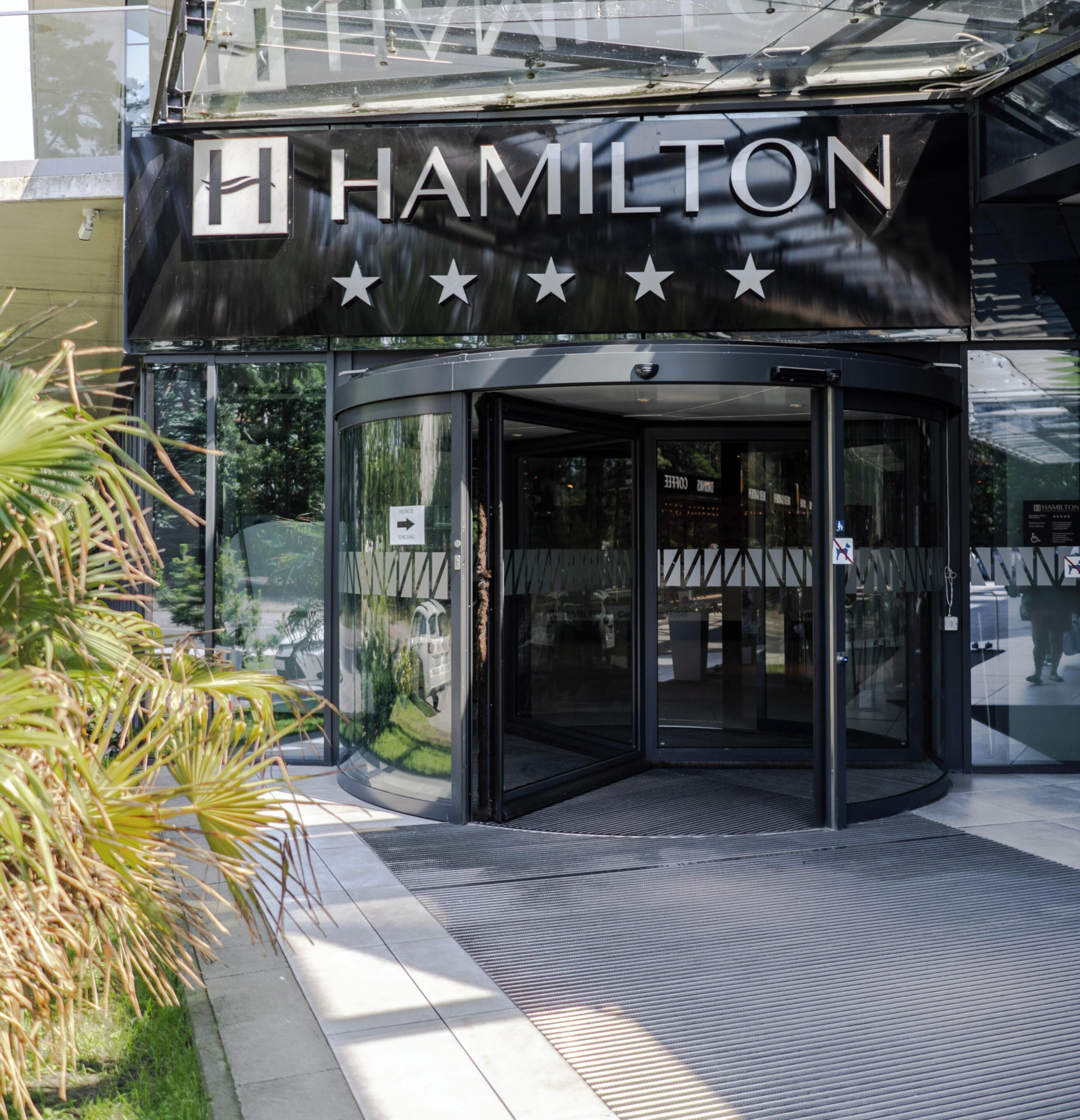 A modern building with a glass entrance and the word 'HAMILTON' prominently displayed.
