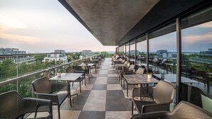 A rooftop terrace with tables and chairs, offering a view of the cityscape. - Hamilton Conference Hotel Spa & Wellness (Swinoujscie)