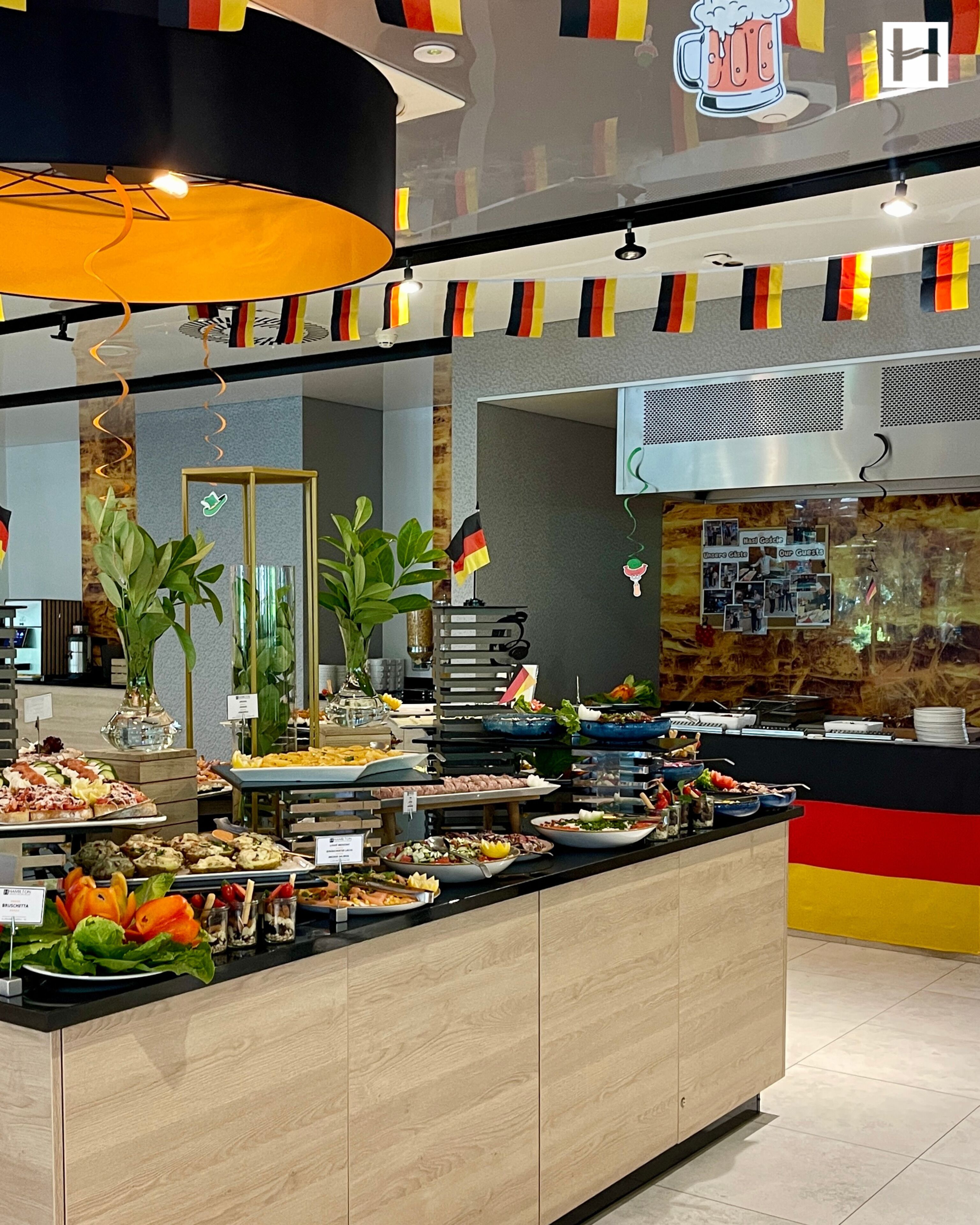 A buffet area with various food options, a bar area, and a seating section with a counter.