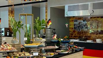 A buffet area with various food options, a bar area, and a seating section with a counter.