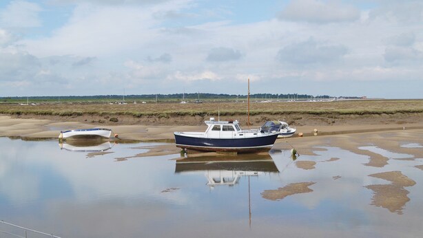 A boat moored on a muddy shore with a clear sky. - 2 bedroom accommodation in Wells-next-the-Sea (Wells-next-the-Sea)