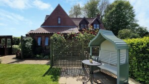 A garden with a bench, a small table, and a gazebo. - THE GARDEN APARTMENT - 28342 (Neatishead, near Norwich)