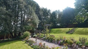 A well-maintained garden with a variety of plants and a pergola structure. - 2 bedroom accommodation in Maidencombe, near Torquay (Maidencombe, near Torquay)