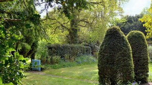 A well-maintained garden with neatly trimmed hedges, a variety of flowering plants, and a clear pathway. - 3 bedroom accommodation in Passfield Common, near Liphook (Passfield Common, near Liphook)