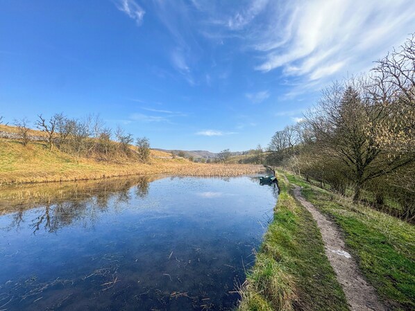 A calm river with a narrow path alongside, surrounded by grassy banks and trees. - 3 bedroom accommodation in Scalegill, near Kirkby Malham (Scalegill, near Kirkby Malham)