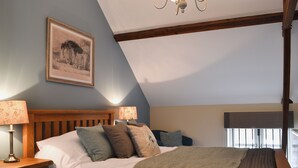 A bedroom with a wooden bed, two bedside lamps, a framed picture on the wall, and a window with blinds. - 2 bedroom accommodation in Myddle, near Shrewsbury (Myddle, near Shrewsbury)