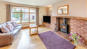 A living room with a sofa, TV, fireplace, and large windows. - 2 bedroom accommodation in Alston (Alston)