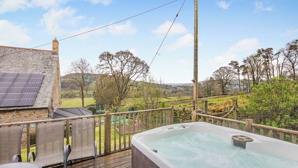 A hot tub on a wooden deck with a view of a rural landscape. - 2 bedroom accommodation in Alston (Alston)