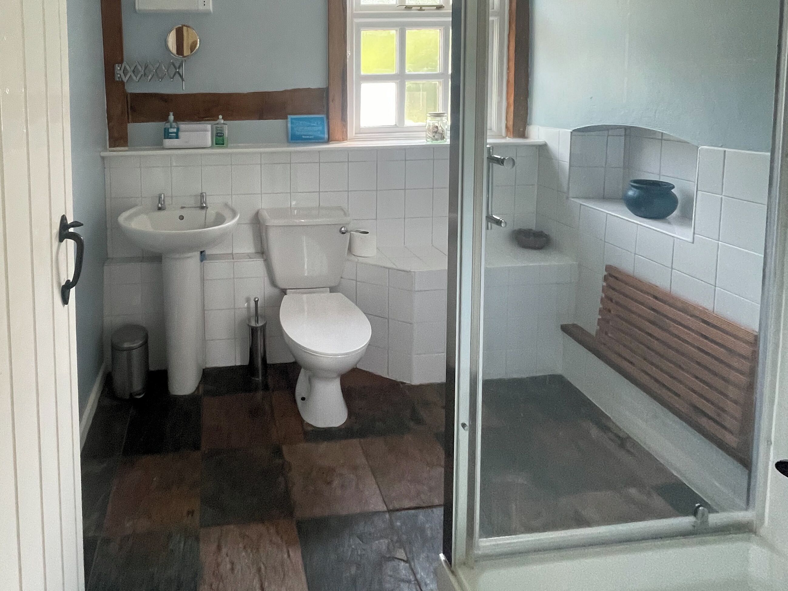 A bathroom with a toilet, sink, and shower.