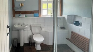A bathroom with a toilet, sink, and shower. - Orchard Bank Cottage (Little London, near Gloucester)
