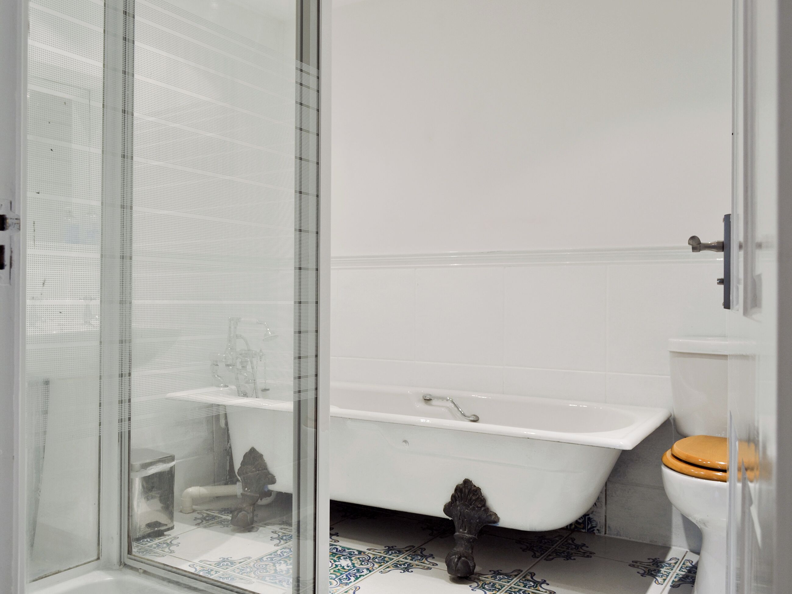 A bathroom with a bathtub, toilet, and shower area.