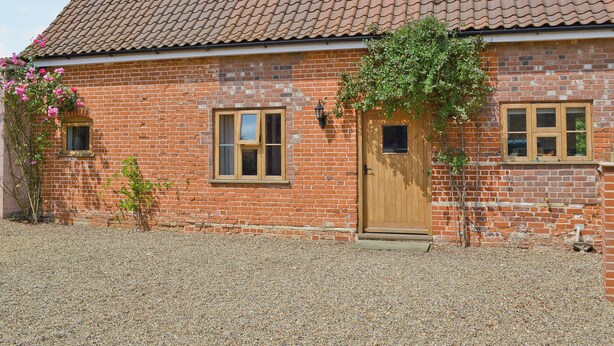 A brick house with a tiled roof, a wooden door, and a small window. - 2 bedroom accommodation in Aldeby, near Beccles (Aldeby, near Beccles)