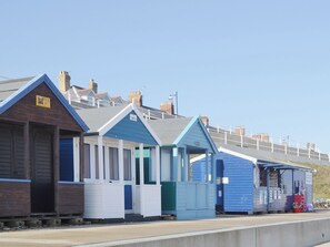 A row of beach huts with a clear sky above.