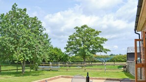 An outdoor patio with a table and chairs, a bottle, and a wine glass. - 2 bedroom accommodation in Aldeby, near Beccles (Aldeby, near Beccles)