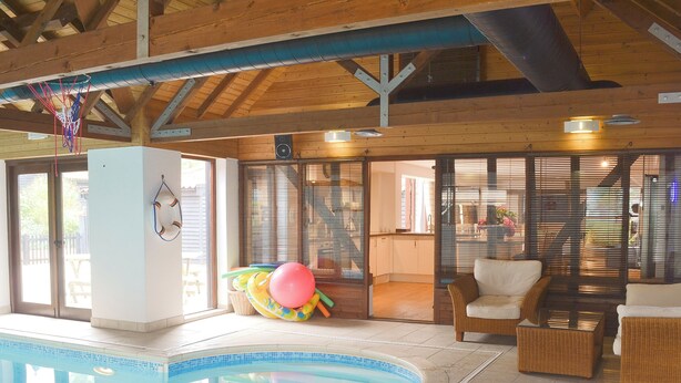 A pool area with a clear view of the pool, a chair, and a wicker sofa. - 5 bedroom accommodation in Botesdale, near Diss (Botesdale, near Diss)