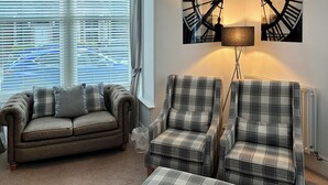 A living room with a grey sofa, two plaid armchairs, and a matching ottoman. - 3 bedroom accommodation in Keswick (Keswick)
