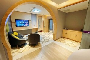 Un salon moderne avec un téléviseur, des sièges et un sol à motifs.