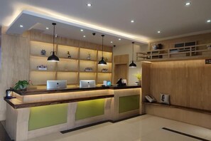 A reception area with a wooden reception desk, multiple computer monitors, and pendant lighting.