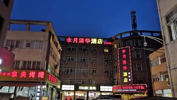 A hotel with multiple floors, a prominent water tower, and several illuminated signs.