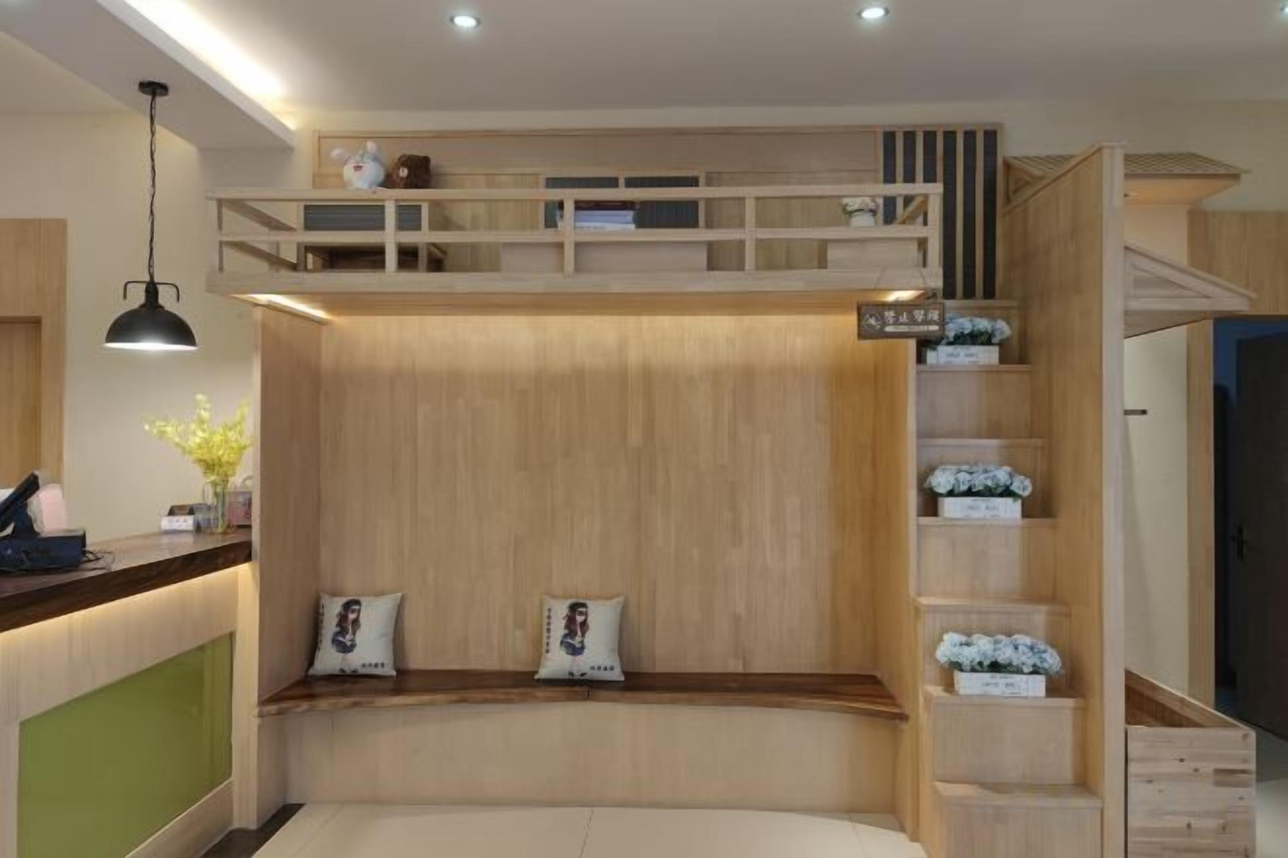 A room with a bunk bed, a desk with a chair, and a shelf with decorative items.