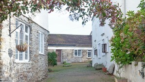 A stone building with a brick pathway leading to a door. - 2 bedroom accommodation in Looe (Looe)