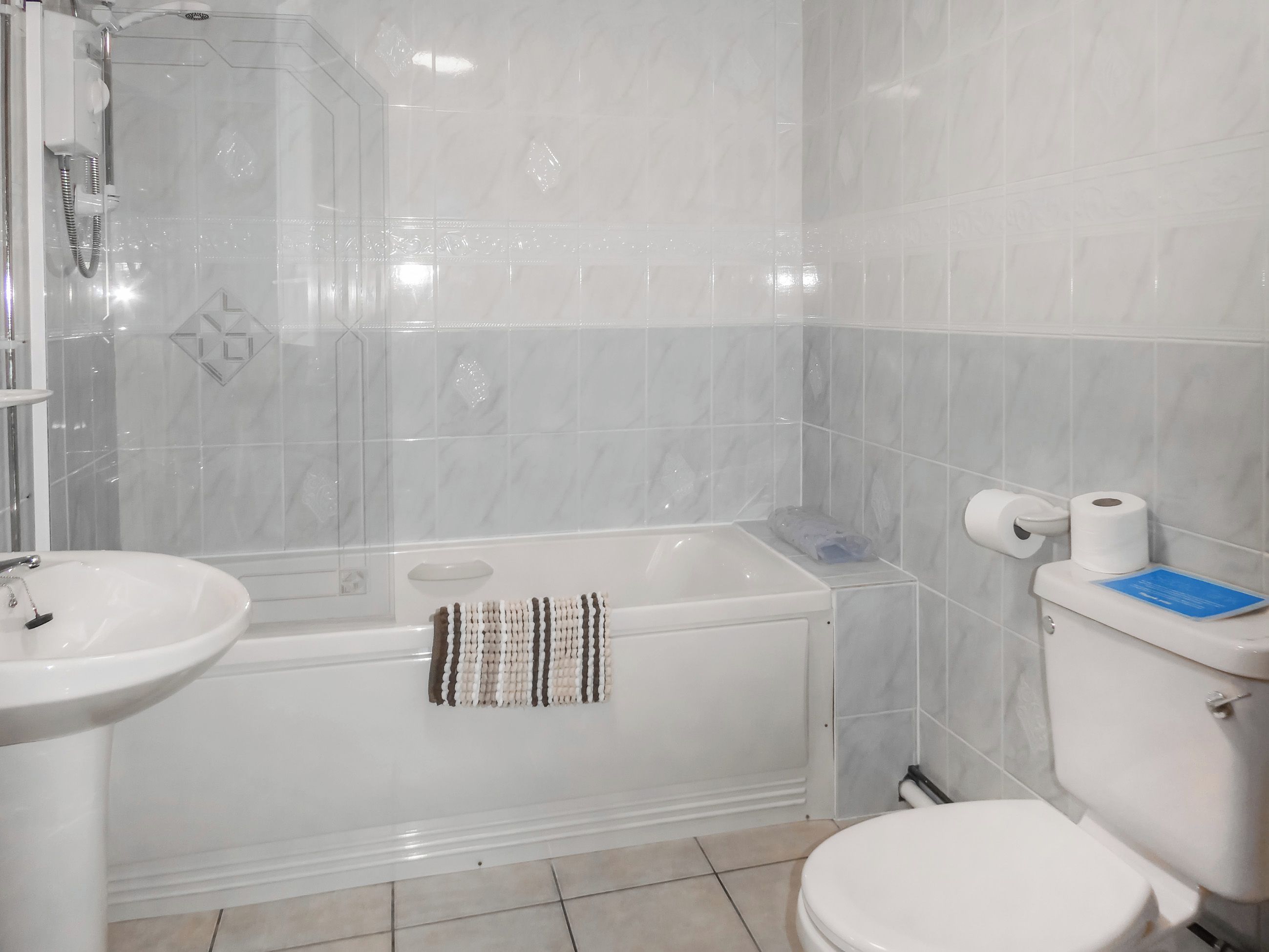A bathroom with a bathtub, a sink, and a toilet.